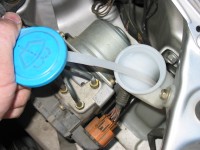 Washer fluid is checked and filled in a reservoir marked with a windshield wiper diagram.