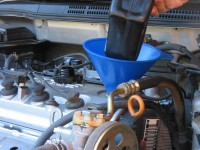 Add oil to the engine using a funnel for less mess.