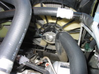 Coolant from the engine is circulated from the left hose, through the radiator, cooled by the fan (center), and returns to the engine via the right hose.